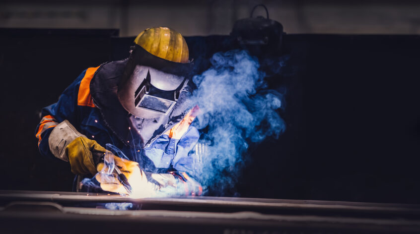 A worker welding in a factory. Heavy industry, welder work